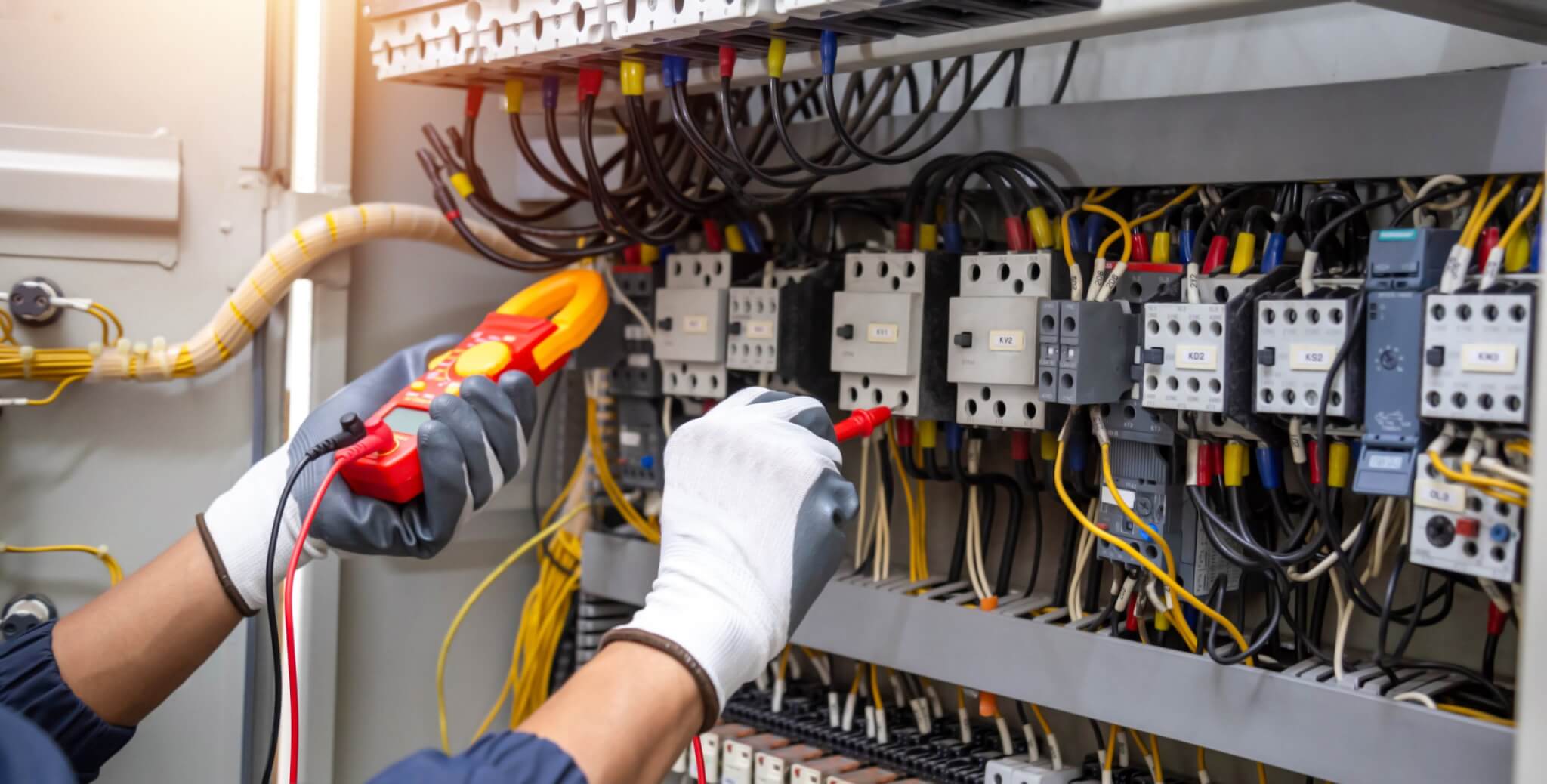 Electricity and electrical maintenance service, Engineer hand holding AC voltmeter checking electric current voltage at circuit breaker terminal and cable